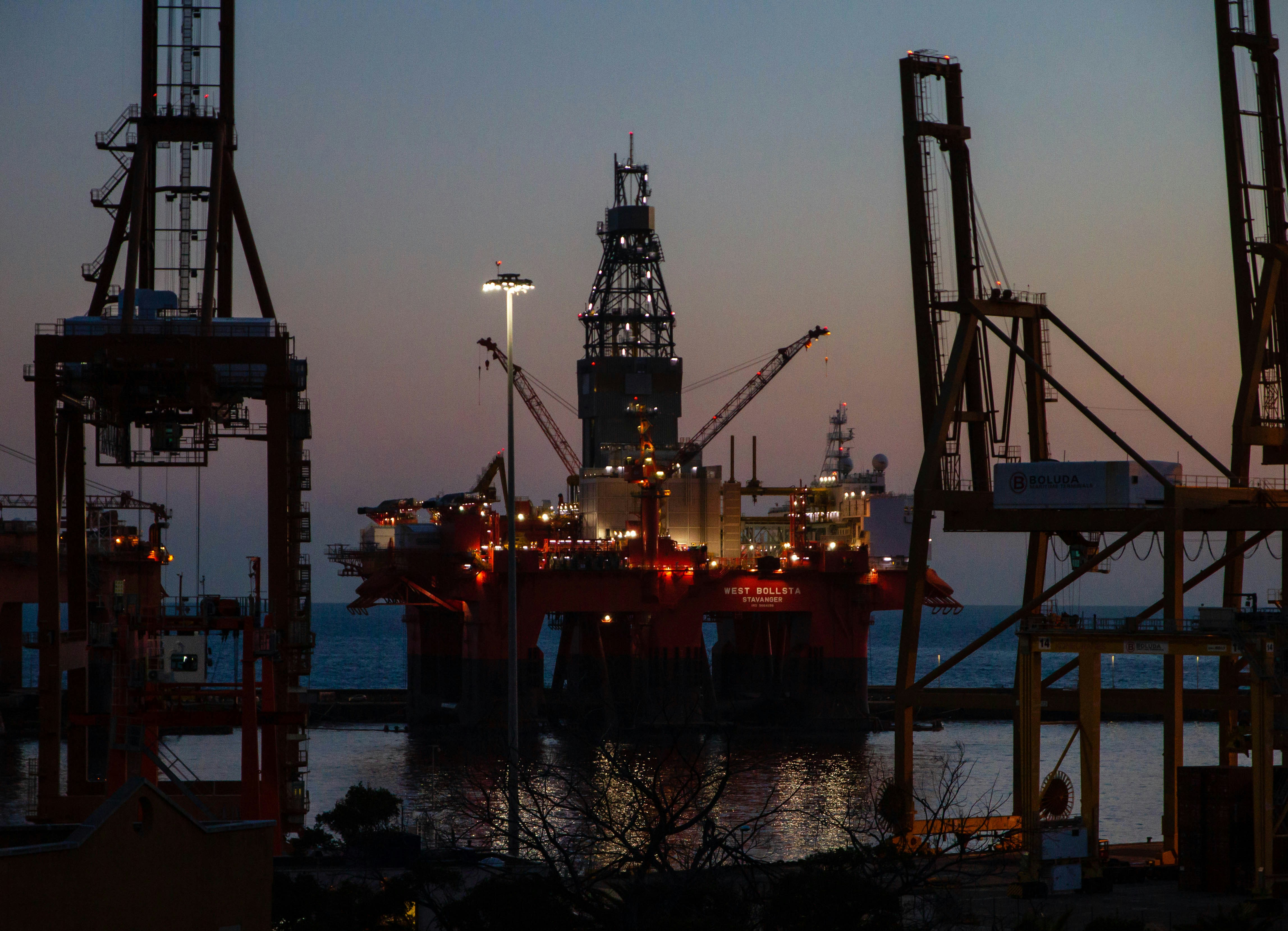 Offshore drilling rig at port at dusk